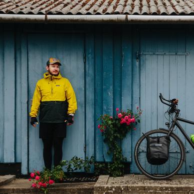 Mann mit gepacktem Fahrrad vor einem Haus auf dem Dänischen Ostseeradweg in Südjütland